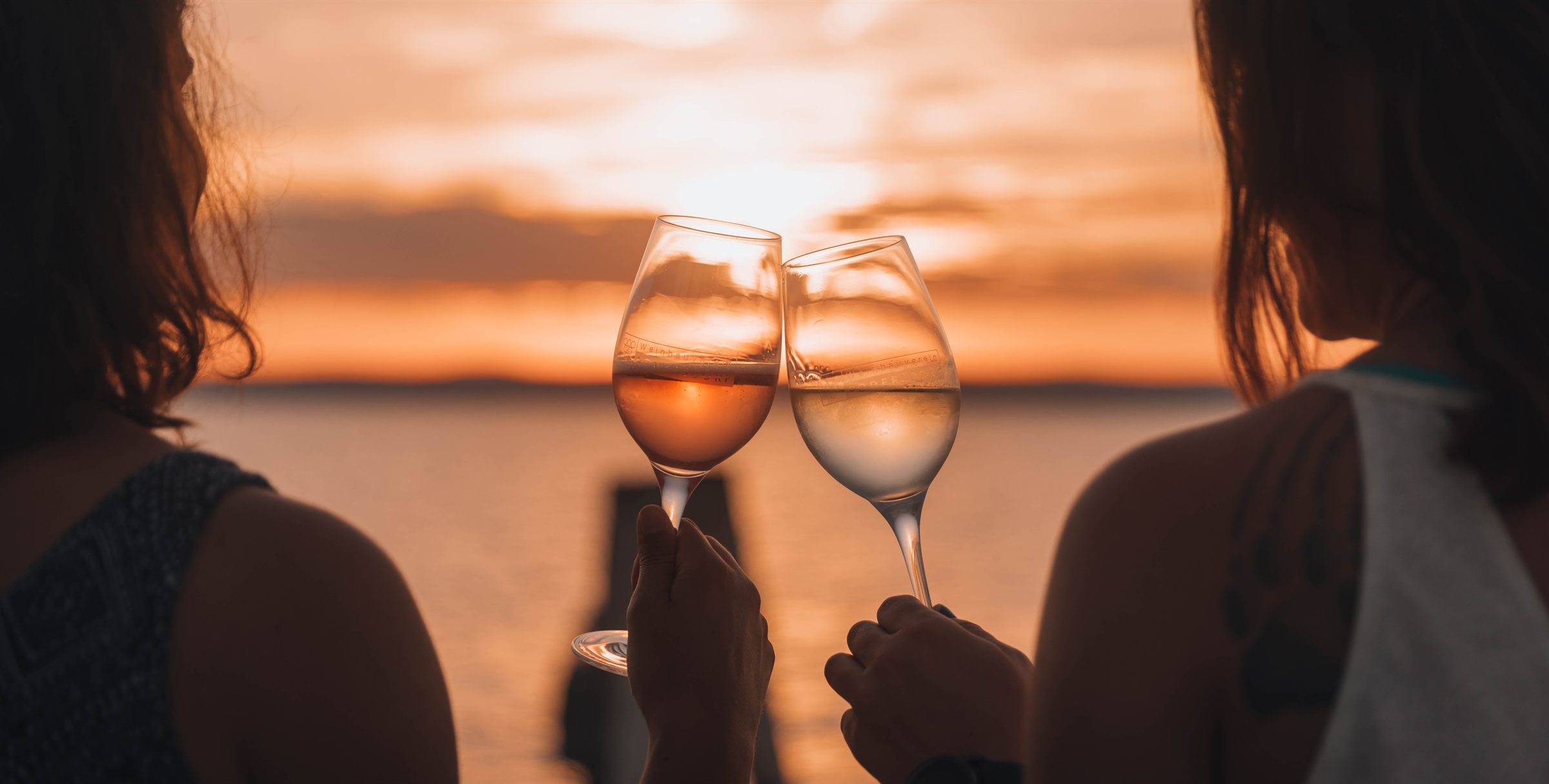 Zwei Weingläser vor dem Sonnenuntergang über dem Neusiedler See