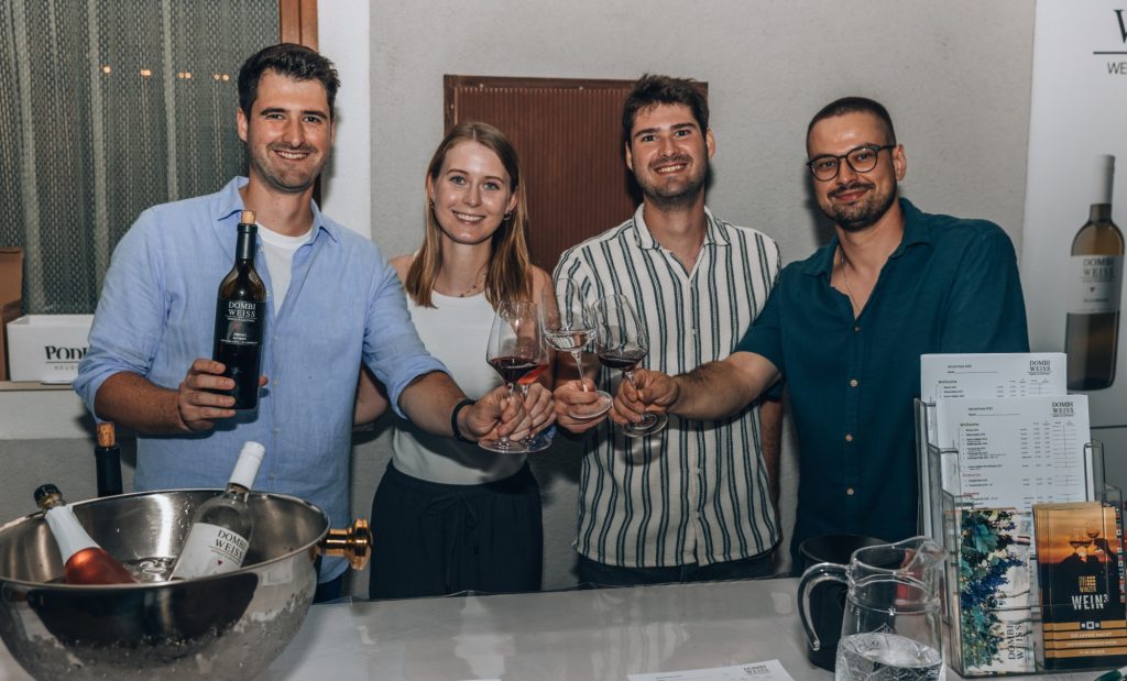 Michael, Anna, Andreas und Daniel stoßen am Weinstand von Dombi-Weiss an
