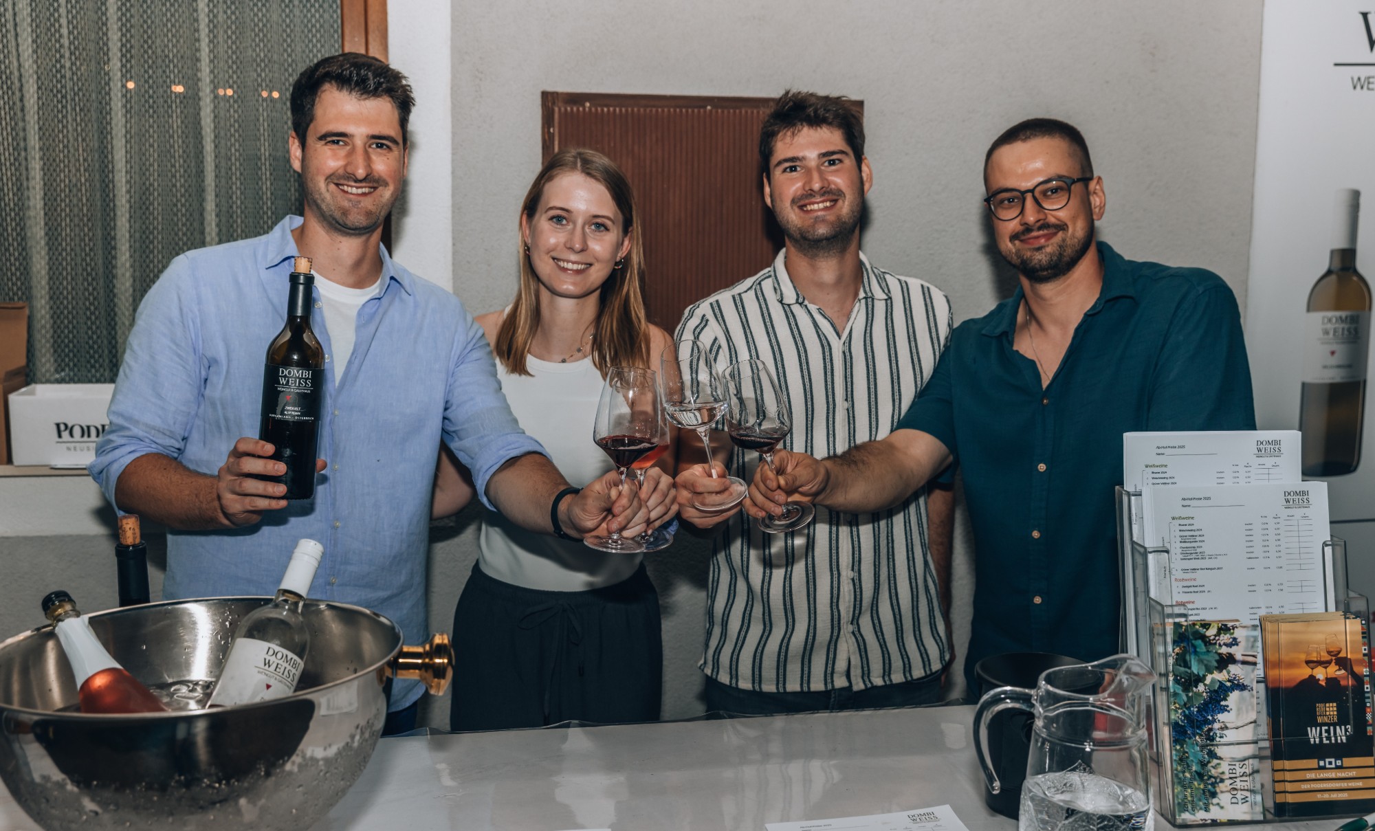 Michael, Anna, Andreas und Daniel stoßen am Weinstand von Dombi-Weiss an