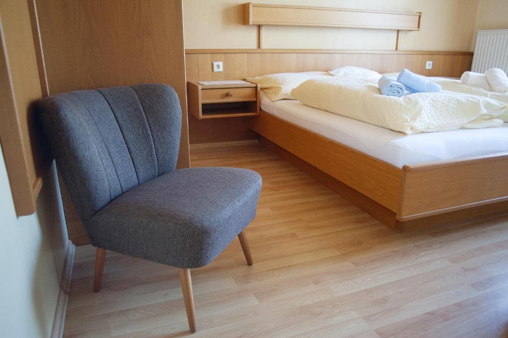 Einzelzimmer mit Sessel und Bett